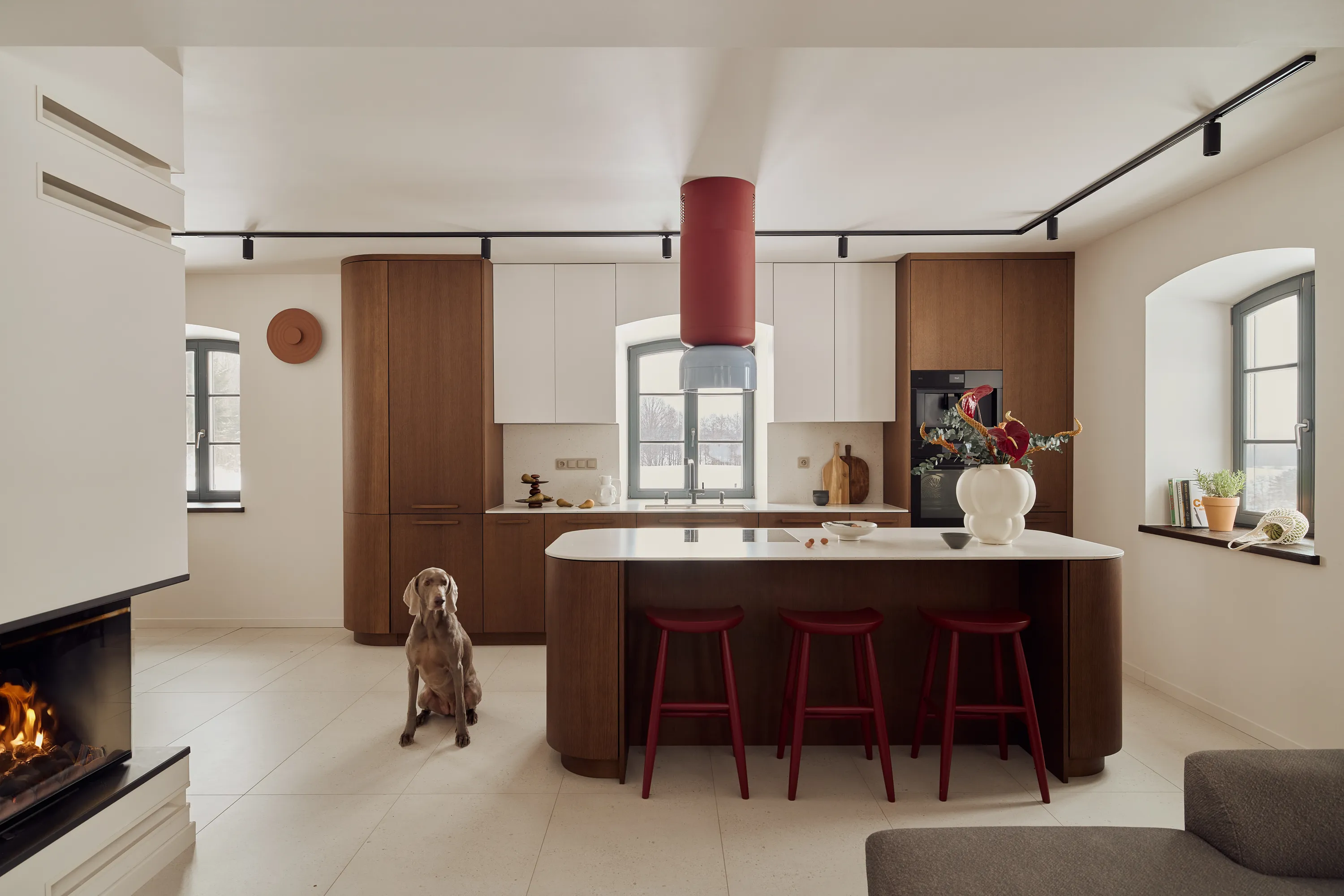 Warm brown oak cabinetry with curved profiles and burgundy accents