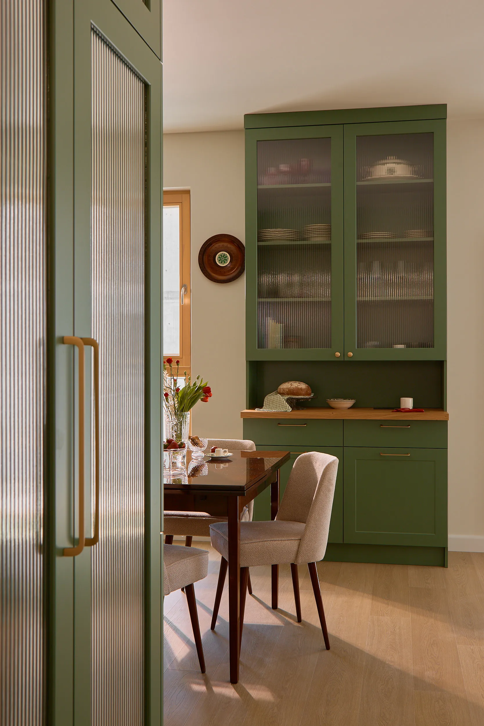 Sage green kitchen with reeded glass cabinetry detail